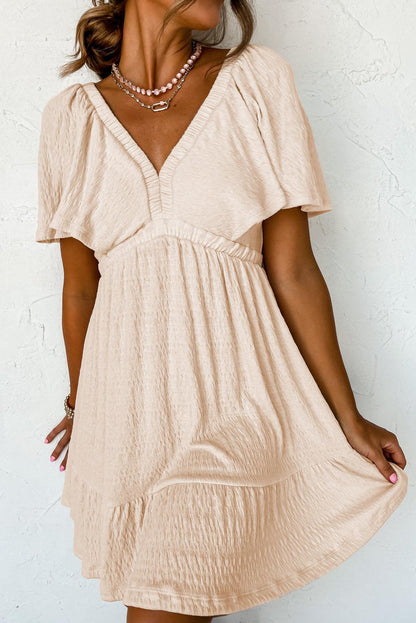 CM | Minivestido beige texturizado con profundo escote en V para mujeres con estilo